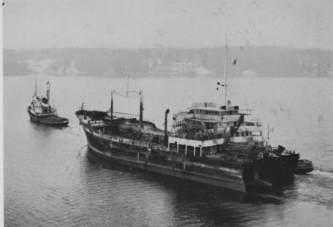 T. GOGSTADs förskepp bogseras in till Stockholm av bärgningsfartyget MERCUR. I bakgrunden syns två Neptunbåtar under bogsering av akterskeppet. 